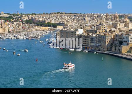 Valletta, Malta - 3. August 2023: Aus der Vogelperspektive auf den Hafen von Valletta mit einer Fähre, die die Menschen in die drei Städte der Stadt bringt Stockfoto