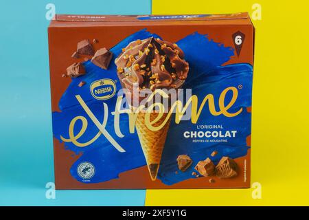 Schachtel Nestle Extreme Eiskegel mit Schokoladengeschmack isoliert auf gelbem und blauem Hintergrund Stockfoto