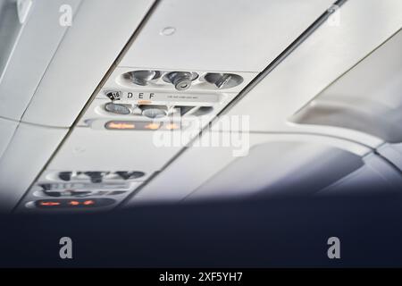 Selektiver Fokus auf Tasten, die sich an der Decke eines Passagierflugzeugs befinden, wo sich Sicherheitselemente wie eine Sauerstoffmaske befinden. Mit Platz zum Kopieren. Hochwertige Fotos Stockfoto