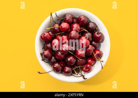 Flache Lage einer süßen Kirschen in Schüssel isoliert auf weißem Hintergrund Stockfoto