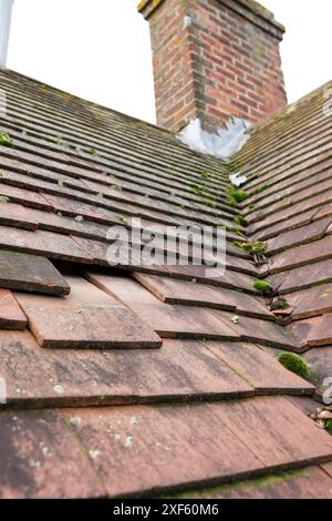 Fehlende und rutschte glatte Dachziegel auf einem geneigten Dach eines alten Hauses in England, Großbritannien Stockfoto