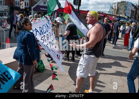 London, Großbritannien. Juli 2024. Ein Mitglied der Öffentlichkeit konfrontiert palästinensische Demonstranten vor dem Bahnhof Southfields. Pro-palästinensische Aktivisten fordern Wimbledon auf, Barclays wegen der finanziellen Beziehungen des Unternehmens zu Israel „fallen zu lassen“. Quelle: SOPA Images Limited/Alamy Live News Stockfoto