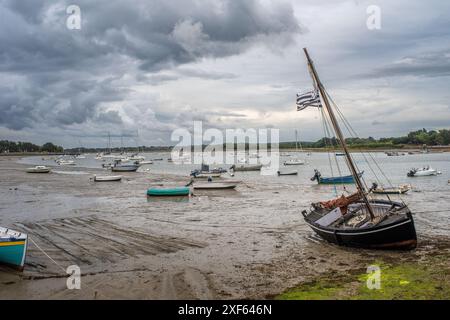 Eine Szene von Booten, die bei Ebbe in Vannes, Bretagne, Frankreich gestrandet sind. Bedeckter Himmel, der den friedlichen Küstenzauber widerspiegelt. Stockfoto