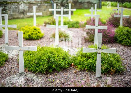 Eine ruhige Szene eines historischen Friedhofs mit weißen Kreuzen in Guehenno, Bretagne, Frankreich. Fängt Gefühle des Friedens und des historischen Zeichens ein Stockfoto