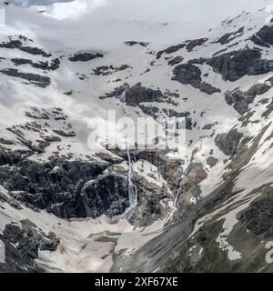 Luftlandcape, aus einem Segelflugzeug, mit Wasserfall unter schmelzendem Gletscher auf der Bernina-Gebirgsseite, von oben im hellen Sommerlicht, Alp Stockfoto