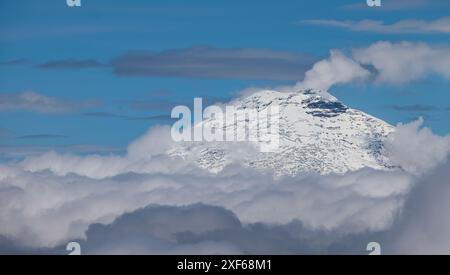 Blick vom Flugzeugfenster auf den Pichincha-Vulkan, bedeckt mit Schnee über der Wolkenbasis, Ecuador, Südamerika Stockfoto