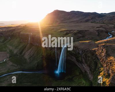 Blick von oben, atemberaubender Blick aus der Luft auf den Seljalandsfoss Wasserfall bei Sonnenuntergang. Seljalandsfoss ist einer der beeindruckendsten Wasserfälle des Landes. Stockfoto