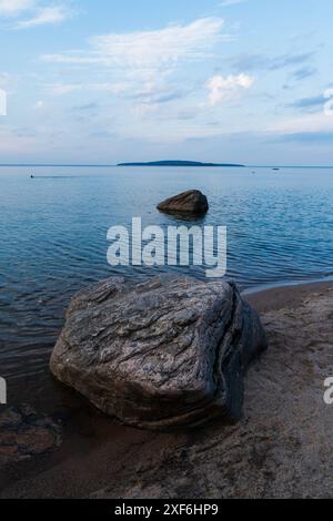 Ein malerischer Blick auf einen ruhigen See mit großen Graniten im Vordergrund im Awenda Provincial Park, Ontario, Kanada Stockfoto