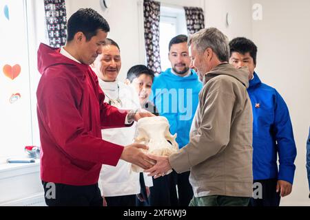 König Frederik X. erhält ein Geschenk in Form eines Walroßkopfes mit Verzierungen in Form von Schnitzereien während eines Kaffemiks in Attu in Grönland am Montag, 1. Juli 2024. Der Walrosser wurde in der Nähe lokaler Jäger geschossen und Schnitzereien wurden von einem lokalen Künstler gemacht. Das Dorf Attu hat etwa 170 Einwohner und befindet sich auf einer kleineren Insel gleichen Namens in der Gemeinde Qeqertalik. Das Königspaar besucht offiziell Grönland vom 29. Juni bis 6. Juli 2024. Der Besuch beginnt in der Disko Bay und das königliche Paar reist dann mit Dannebrog nach Süden entlang Grönlands Westküste. Stockfoto