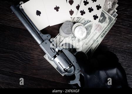 Die Hand eines Toten. Zweipaarige Pokerhand bestehend aus schwarzen Assen und schwarzen Achten und Spielerhand mit Revolverpistole. Stockfoto