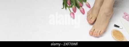 Frau mit ordentlichen Zehennägeln nach Pediküre und Blumen auf weißem Handtuch, Draufsicht. Bannerdesign mit Platz für Text Stockfoto