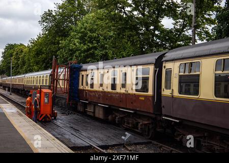 Alte Zugwagen an einem Bahnsteig, die beim Vorbeifahren mit einer automatischen Bürste gereinigt werden Stockfoto