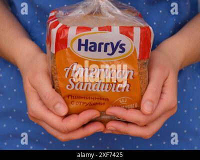 Tambow, Russische Föderation - 12. Januar 2024 Harrys American Sandwich Brotpackung in Frauenhänden Stockfoto