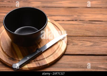 Schneidebrett und Schüssel auf hölzernem Hintergrund Stockfoto