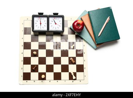Komposition mit Schachbrett, Stücken, Uhr und Büchern auf weißem Hintergrund Stockfoto