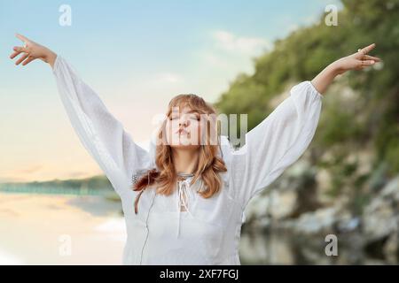 Porträt einer jungen Schamanin, die in der Nähe des Flusses meditiert Stockfoto