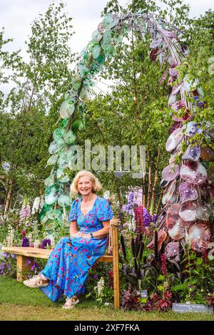 London, Großbritannien. Juli 2024. Janet Turnes aus Stonebarn Landscapes, die den Garten gebaut hat, posiert mit einer schönen Freundschaftsskulptur im RHS Britain in Bloom 60th Anniversary - Gardening for People and Plant Feature Garden. Pressevorschau beim RHS Hampton Court Palace Garden Festival (ehemals Hampton Court Flower Show). Das Festival wird am Dienstag, den 2. Juli, für die Öffentlichkeit geöffnet, um das Beste der Gartenarbeit im Sommer zu feiern. Quelle: Imageplotter/Alamy Live News Stockfoto