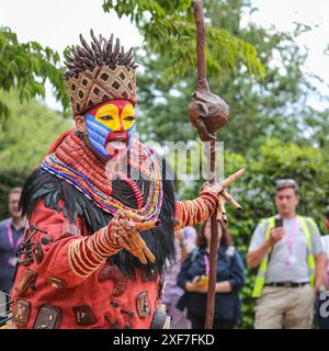 London, Großbritannien. Juli 2024. Im Lion King Anniversary Garden Show Garden, Star von Disney's The Lion King in the West End, spielt Thenjiwe Nofemele den berühmten „Circle of Life“ in ihrem vollen Rafiki-Kostüm, begleitet von fliegenden Vogelpuppen und Darstellern, um das 25. Jahr der Show im Lyceum Theatre zu feiern. Pressevorschau beim RHS Hampton Court Palace Garden Festival (ehemals Hampton Court Flower Show). Das Festival wird am Dienstag, den 2. Juli, für die Öffentlichkeit geöffnet, um das Beste der Gartenarbeit im Sommer zu feiern. Quelle: Imageplotter/Alamy Live News Stockfoto