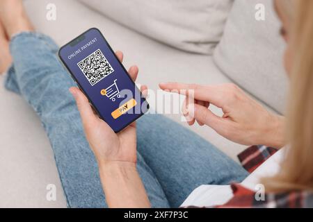 Frau, die Online-Zahlungsanwendung auf dem Handy zu Hause benutzt, Nahaufnahme Stockfoto