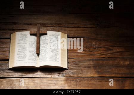 Bibel und Kreuz auf Holztisch, über dem Bild mit Platz für Text. Religion des Christentums Stockfoto