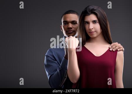 Stilvolles, multiethnisches Paar posiert selbstbewusst in einem Studio und zeigt Liebe und Zuneigung. Ihre interrassische Beziehung symbolisiert Einheit und Harmonie Stockfoto
