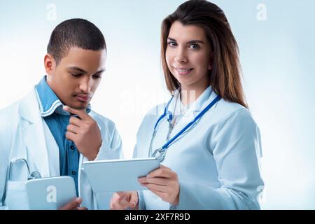 Zwei medizinische Fachkräfte diskutieren den Bericht eines Patienten auf einem Tablet und zeigen Teamarbeit und Mitgefühl in einem Krankenhaus Stockfoto