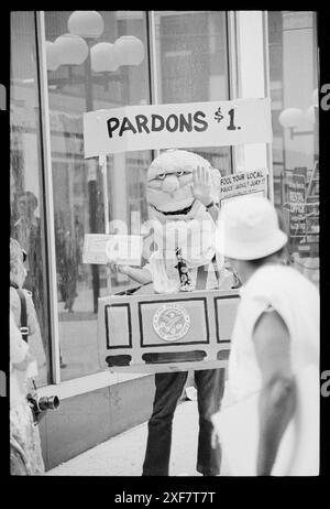 Der maskierte Demonstrant, der als Präsident Gerald Ford verkleidet ist und ein Schild mit der Aufschrift 'Pardons $1' trägt, zieht die Aufmerksamkeit der Passanten auf den Democratic National Convention, New York, 12. Juli 1976 auf sich. (Foto: Warren K Leffler/US News and World Report Collection Stockfoto