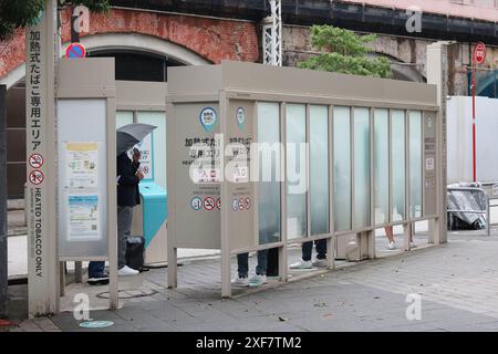 TOKIO, JAPAN - 23. Juni 2024: Ein ausgewiesener Raucherbereich auf einer Straße im Tokioter Shimbashi-Gebiet, der nur für erhitzte Tabakprodukte bestimmt ist. Stockfoto