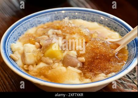 Taiwans klassischer Sommergenuss: Seidiger Tofu-Pudding mit Erdnüssen, süßen Taro-Bällchen und knusprigen Süßkartoffelbällchen. Eine erfrischende Explosion von Texturen und Stockfoto