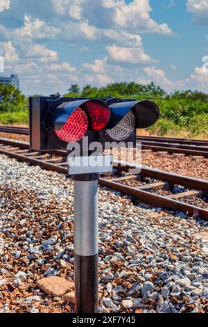 Rote Zugsignalleuchten, moderne Bahngleise auf Schotter in der Nähe der Stadt Stockfoto