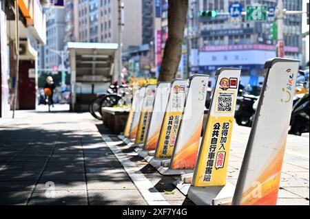 Taiwan - 29. Januar 2024: Leerer gemeinsamer Fahrraddock an der MRT Dongmen Station während der Hauptverkehrszeit mit Radfahrer im Hintergrund. Stockfoto