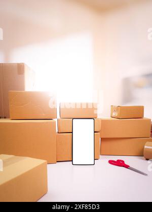 Warenlieferkonzept, Mobiltelefon mit leerem weißen Bildschirm und Pappschachteln auf dem Schreibtisch, Kopierraum für Text Stockfoto