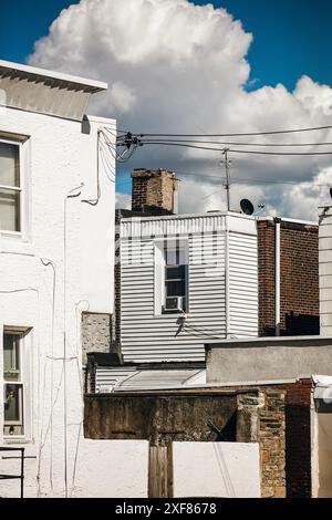 Stadtbild mit Fenstern von Häusern vor blauem Himmel mit Wolken in Port Richmond, Philadelphia, Pennsylvania, 1. Juli 2024 Stockfoto