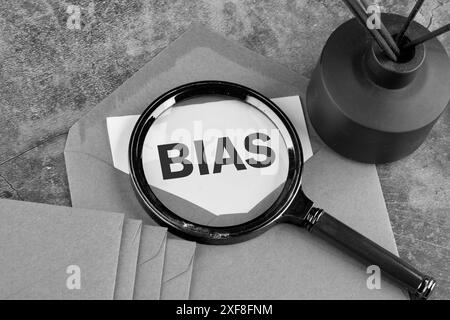 Persönliche Meinungen Vorurteile-Vorurteile-Konzept erschien durch eine Lupe auf einem Blatt Papier, das aus einem Umschlag ragte. Schwarzweißbild Stockfoto