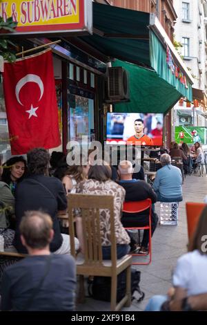 Gäste vor einer Bar in der Naunynstraße in Berlin-Kreuzberg verfolgen das Spiel Türkei gegen Portugal anlässlich der Fußballeuropameisterschaft UEFA EURO 2024. / Gäste vor einer Bar in der Naunynstraße in Berlin-Kreuzberg sehen das Spiel zwischen der Türkei und Portugal während der Fußball-Europameisterschaft UEFA EURO 2024. Schnappschuss-Fotografie/K.M.Krause *** Gäste vor einer Bar in der Naunynstraße in Berlin Kreuzberg sehen das Spiel zwischen der Türkei und Portugal während der Fußball-Europameisterschaft UEFA EURO 2024 Gäste vor einer Bar in der Naunynstraße in Berlin Kreuzberg sehen das Spiel Stockfoto