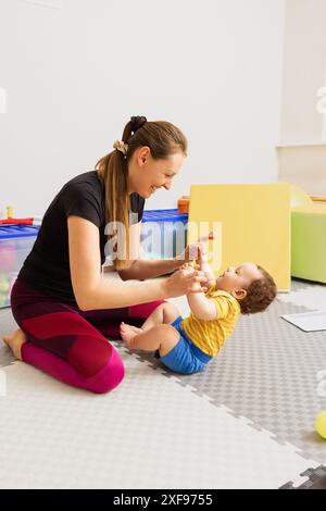 Hypotonie bei Babys, Muskelschwäche. Die Prüfung von Kleinkindreflexen mit Hilfe von Traktionsarmtest und neurologischer Untersuchung im Rehabilitationszentrum Stockfoto