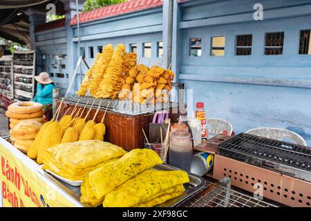 Street Food-Stand, der spiralgeschnittene, frittierte Kartoffelchips auf Spießen verkauft. Frittierte Spieße, asiatisches Streetfood. Frisch gekocht und auf einem Essen ausgestellt Stockfoto