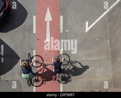 Der Radfahrer wirft einen langen Schatten und fährt auf einem rot markierten Radweg. Miltenberg, Niederfranken, Bayern, Deutschland Stockfoto