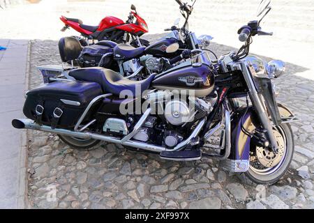 Trinidad, Kuba, Grosse Antillen, Karibik, Mittelamerika, Amerika, mehrere Harley Davidson Motorräder in einer Straße, darunter ein rotes Stockfoto