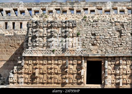 El Palacio, Palast von Kabah, Kabah, Yucatan, Mexiko, Zentralamerika, Nahaufnahme einer Steinmauer mit reich verzierten antiken Masken Stockfoto