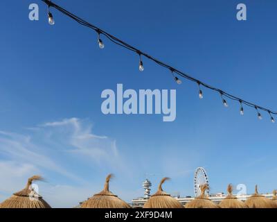 Feenlichter, Strohdächer und ein Riesenrad vor blauem Himmel, scheveningen, niederlande Stockfoto