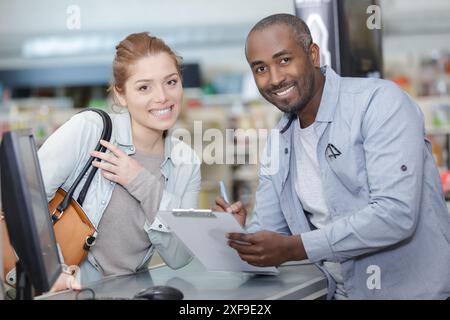 Junger Mann und Frau an der Kasse im Eisenwarenladen Stockfoto