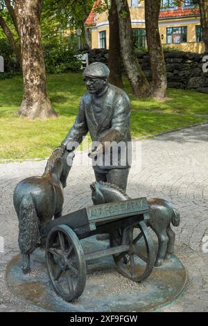 Bronzestatue eines Mannes mit zwei kleinen Pferden in einem Park umgeben von Bäumen, stavanger, norwegen Stockfoto