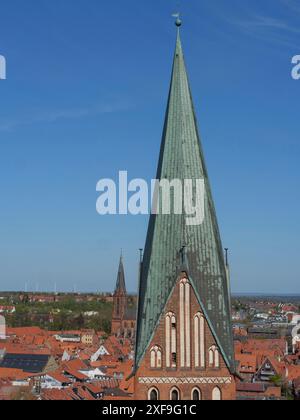 Nahaufnahme eines hohen Kirchturms vor einem klaren blauen Himmel in einem historischen Stadtpanorama, lüneburg, deutschland Stockfoto