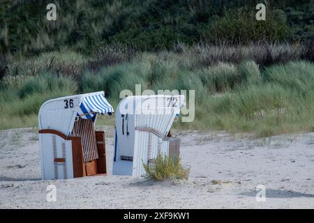 Zwei leere Liegen auf dem Sand vor grasbewachsenen Dünen, spiekeroog, Nordsee, deutschland Stockfoto