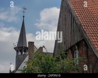 Fachwerkhaus mit Ziegeldach neben einem hohen Turm und blauem Himmel, Steinfurt, Nordrhein-Westfalen, Deutschland Stockfoto