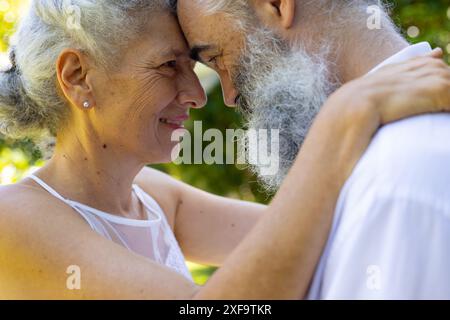 Umarmen und lächeln, Senior Braut und Bräutigam bei der Hochzeit im Park Stockfoto