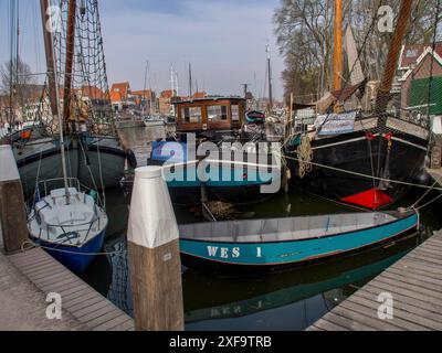 Mehrere Boote liegen im Hafen, umgeben von ruhigem Wasser und Uferbereich, Hoorn, Niederlande Stockfoto