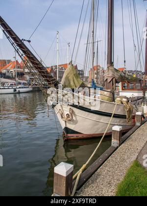 Ein altes Segelboot, im Hafen verankert, mit maritimer Architektur im Hintergrund, Hoorn, Niederlande Stockfoto