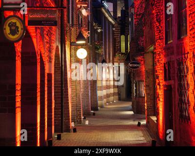 Eine gepflasterte Gasse mit stimmungsvoller Nachtbeleuchtung und beleuchteten Gebäudefassaden, Bremen, Deutschland Stockfoto